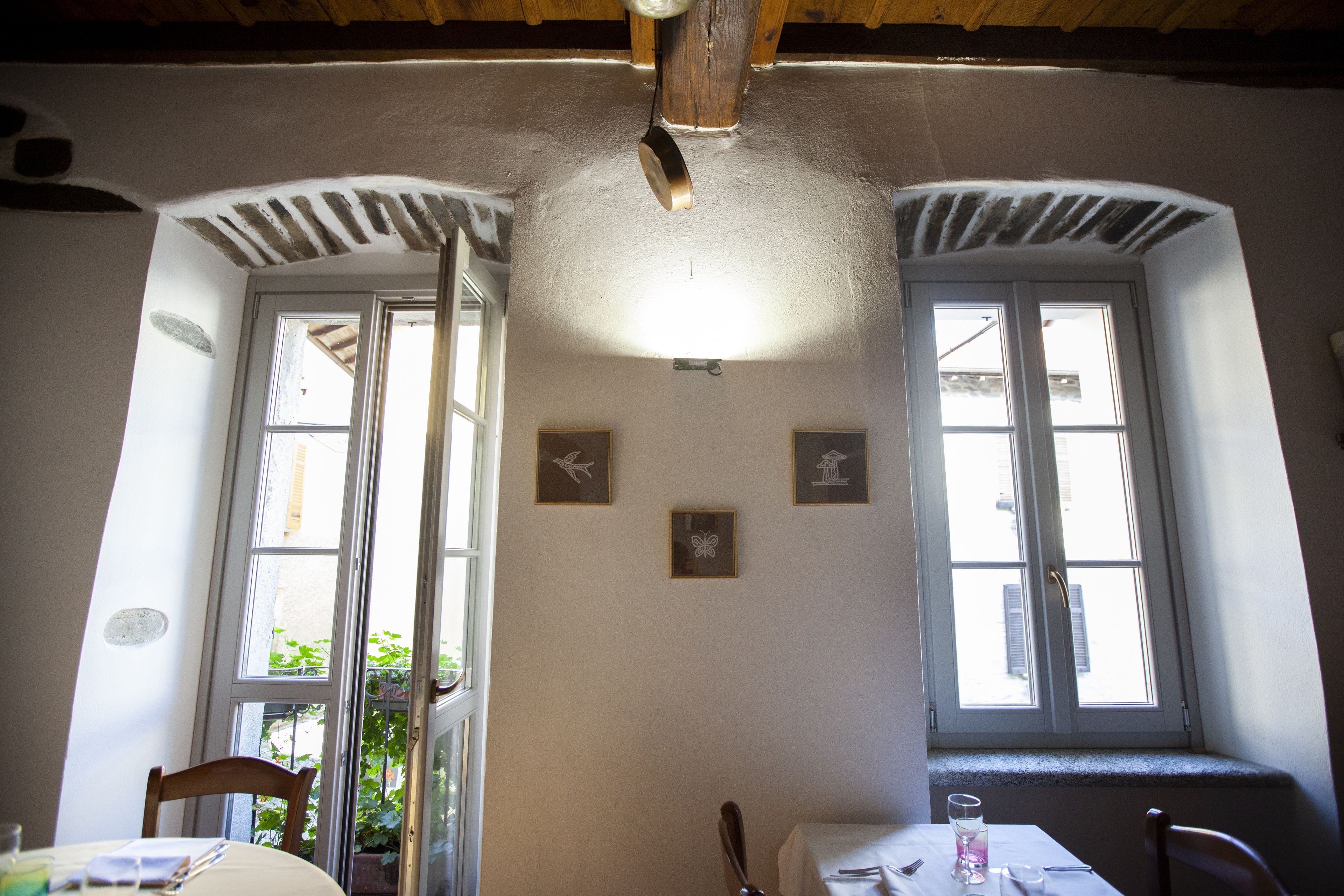 Zona pranzo con tavolo, sedie e finestra vista su spazi verdi.