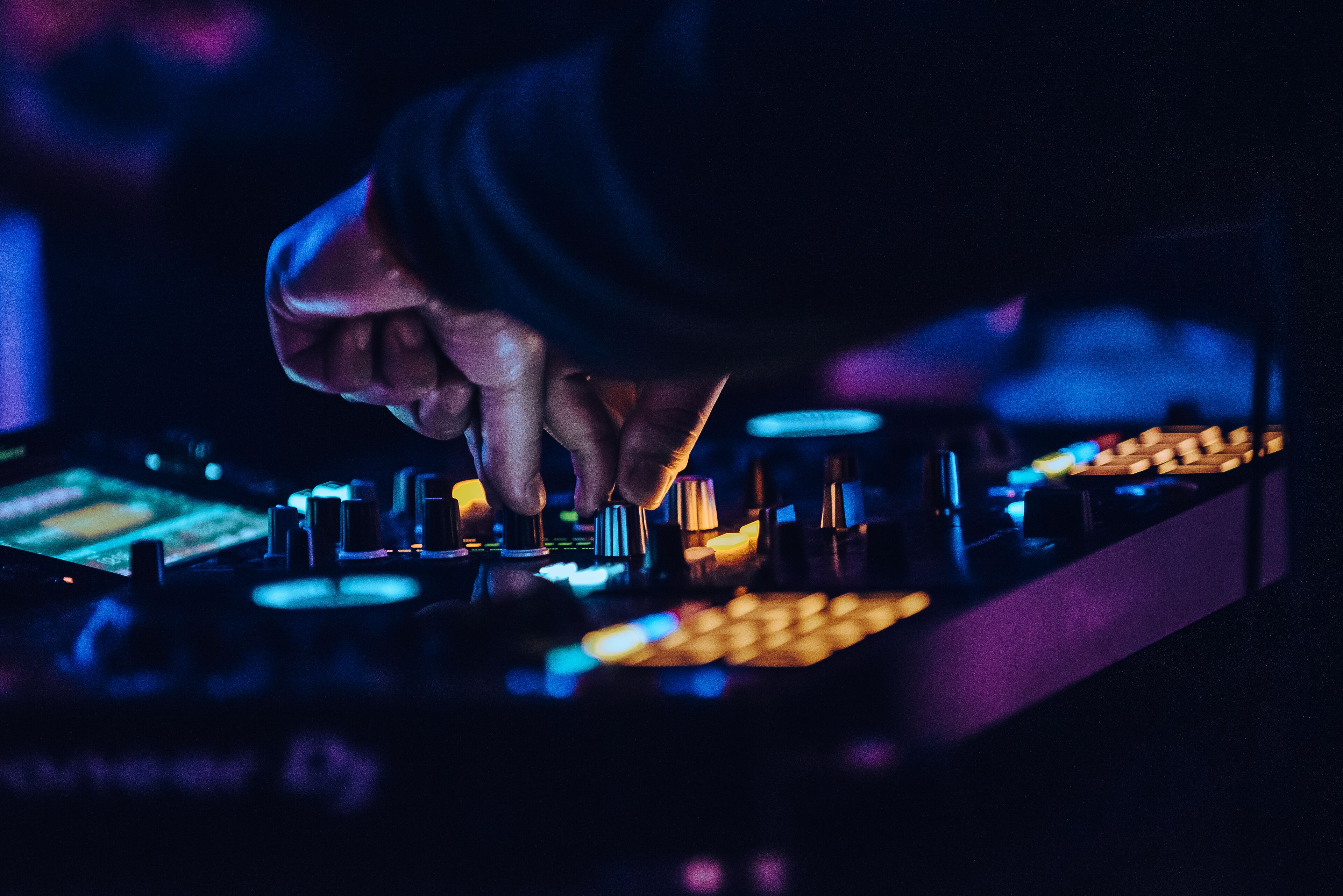 Primer plano de un DJ mezclando música con una mesa de mezclas.