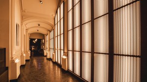 A corridor with patterned wall panels and a herringbone floor. - Harmon House (Brussels)