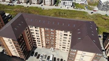 A multi-story residential building with a parking lot in front.