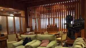 Un salon confortable avec un canapé, des fauteuils, une table basse et un téléviseur.