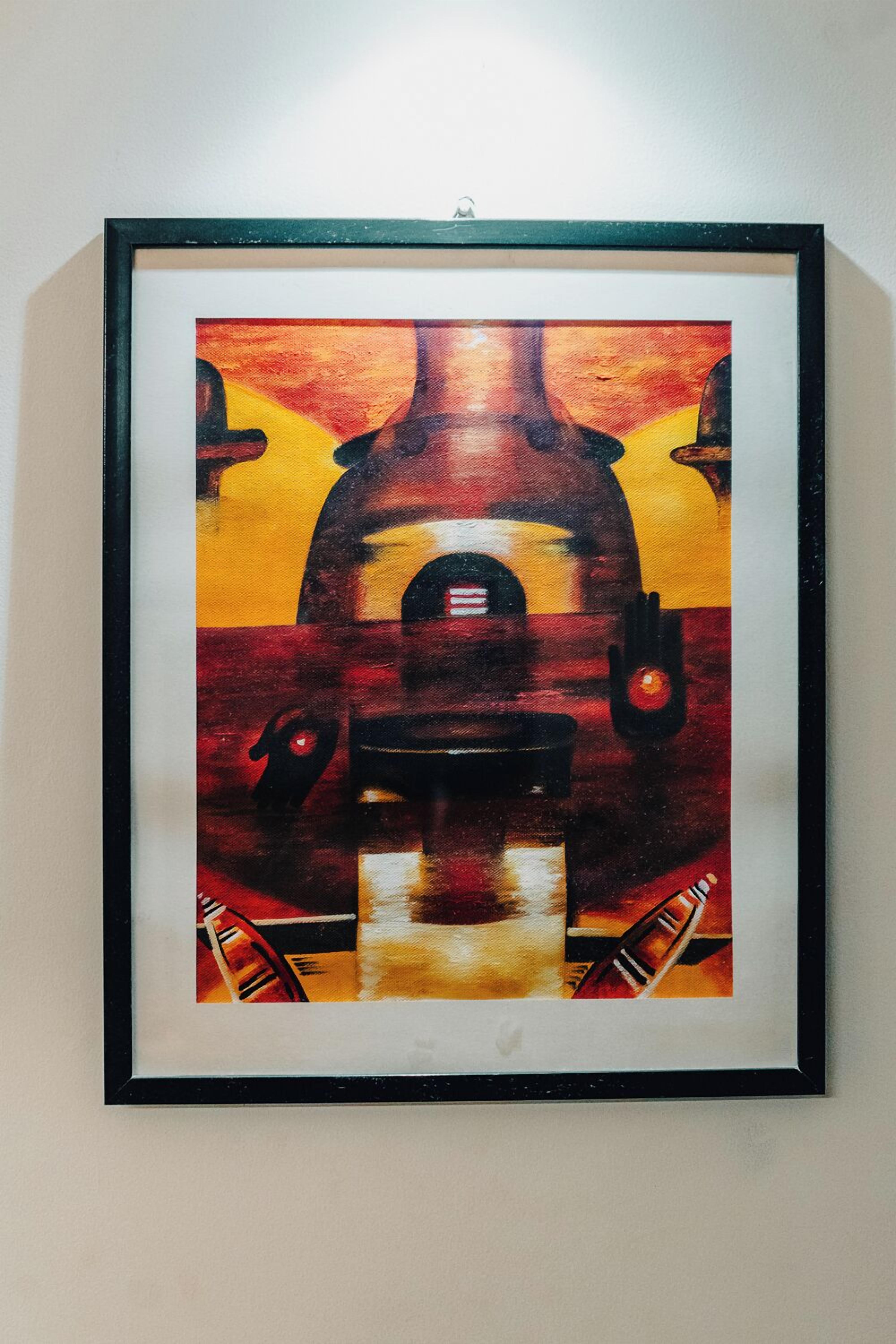 Un tableau encadré représentant un bâtiment doté d’une arche centrale et de deux structures latérales, accroché à un mur sobre.