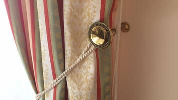 A curtain with a decorative pattern and a metallic pull handle.
