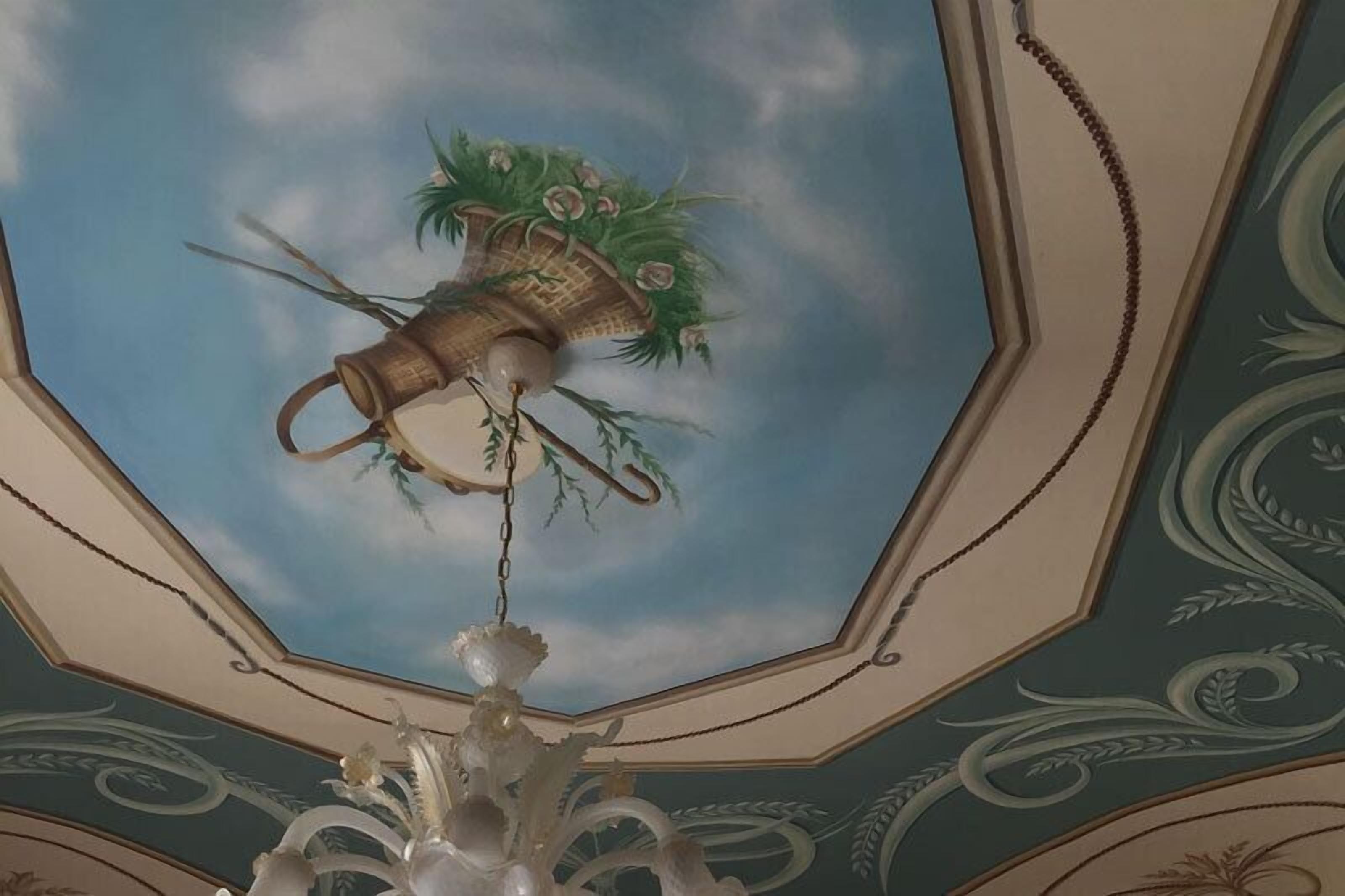A ceiling with a decorative hanging basket and a chandelier.