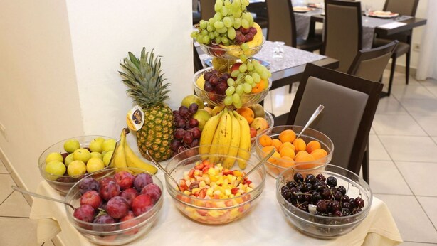 A fruit display with various types of fruits in bowls and a fruit tree centerpiece. - Hotel Nautilus (Forte dei Marmi)