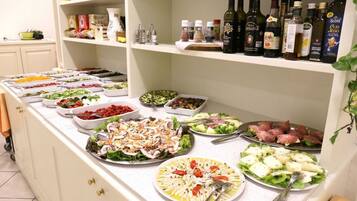 A buffet with various dishes and a selection of olive oils on shelves.