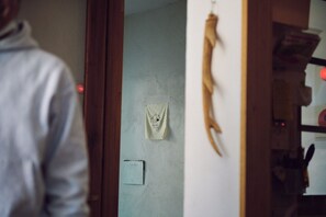 A room with a wooden door, a light switch, and a wall-mounted light fixture. - SMALL TOWN HOTEL Hakodate (Hakodate)