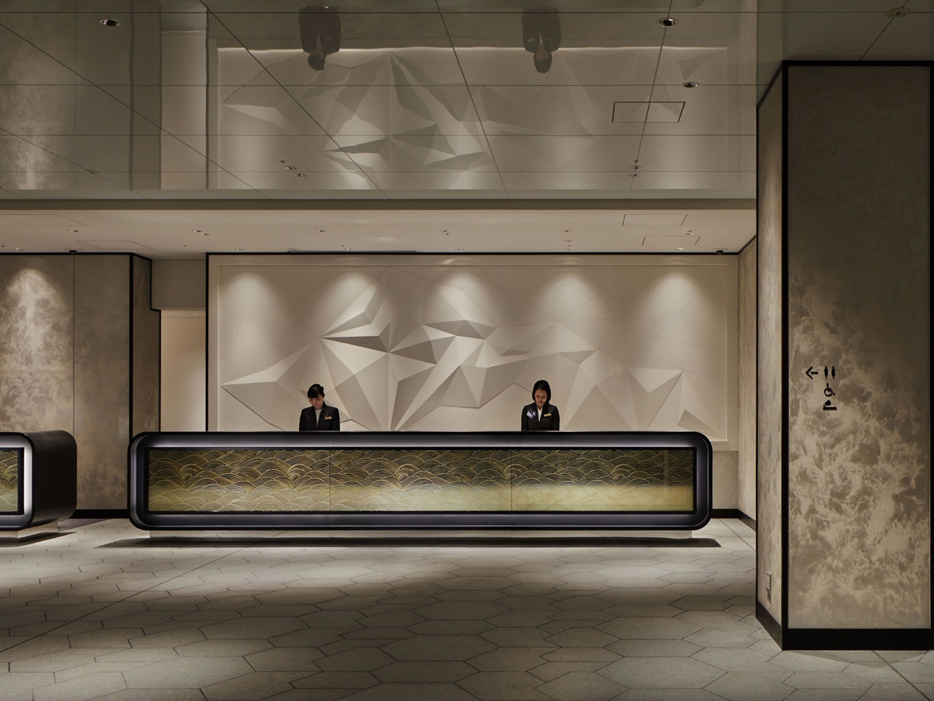 A reception desk with geometric wall patterns and a modern design.