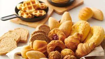 A variety of baked goods including bread, croissants, muffins, and waffles.