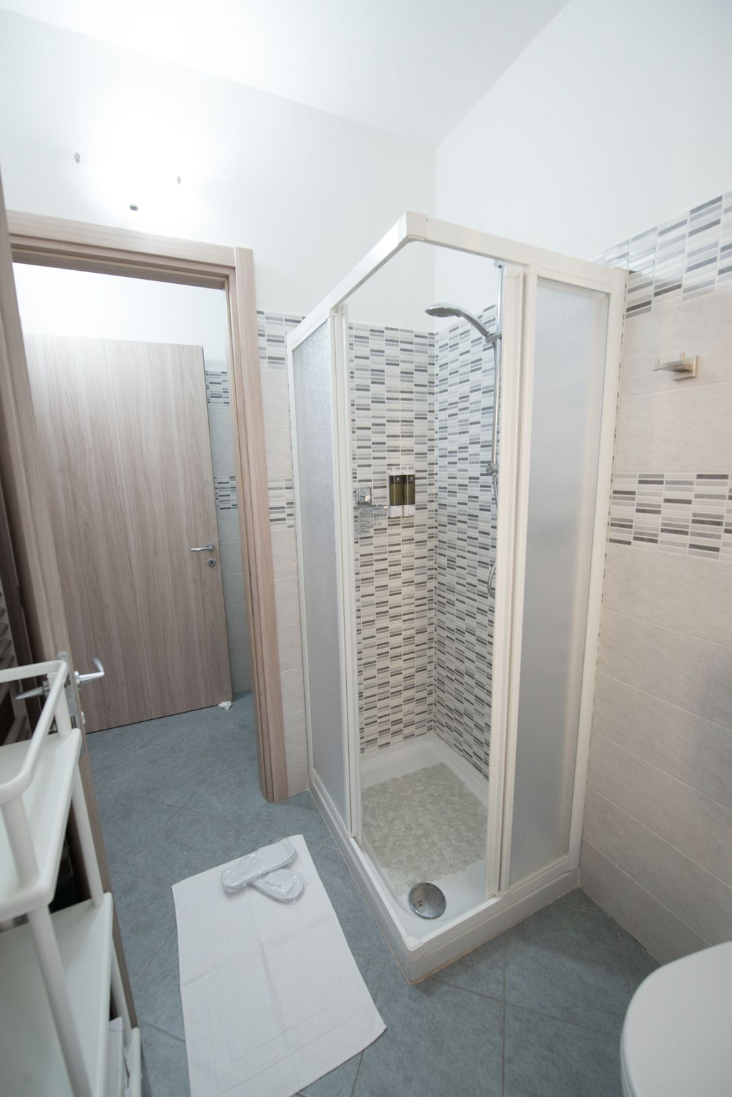 A modern bathroom with a shower enclosure, a toilet, and a sink.