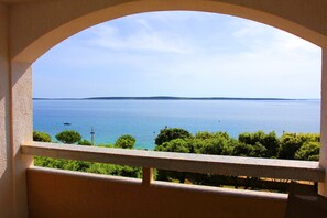 A balcony with a view of a calm sea and distant land. - Apartments Mak (Kolan)