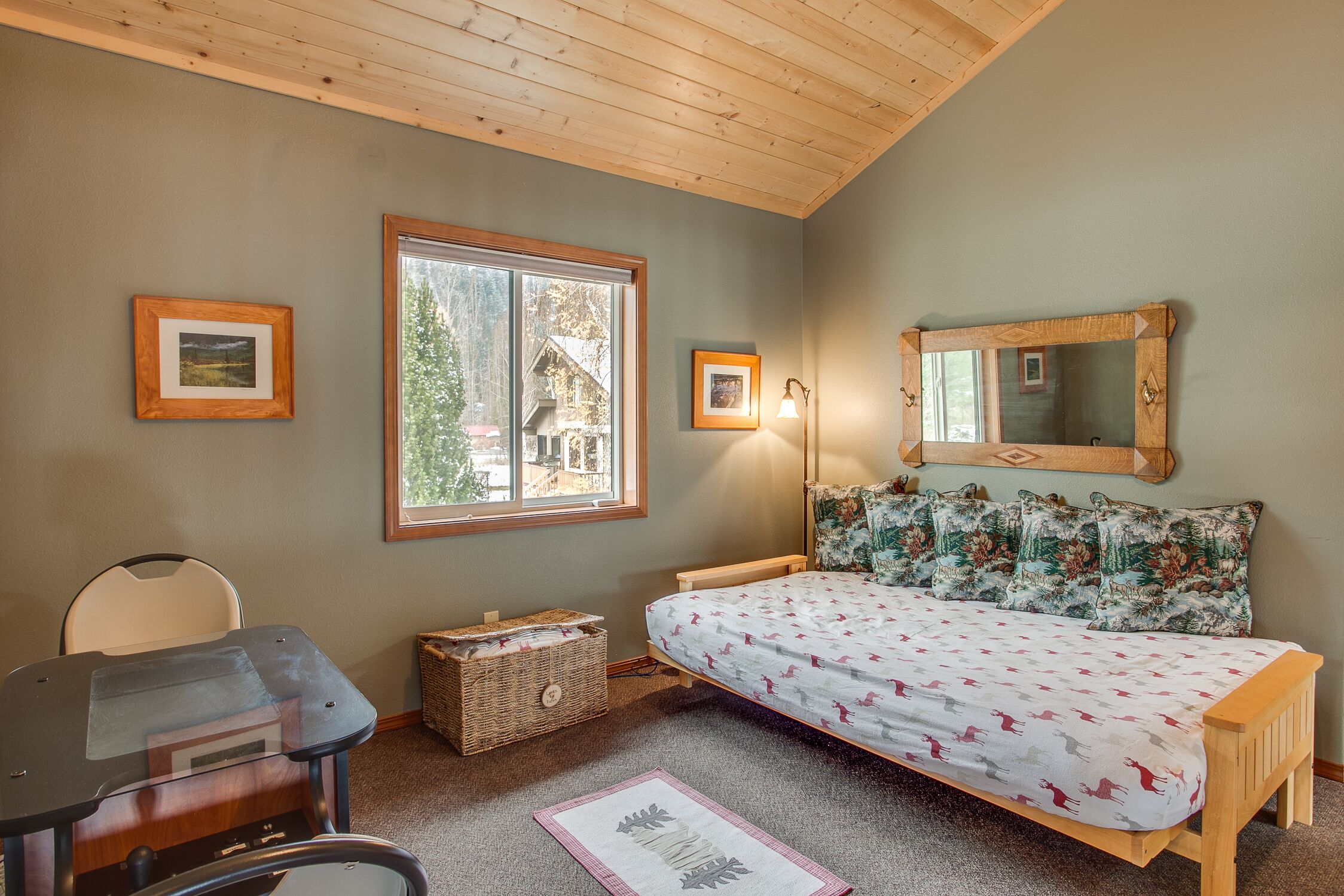 Une chambre à coucher avec un lit, un bureau, une chaise, une fenêtre et un miroir.