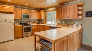 A kitchen with wooden cabinets, stainless steel appliances, and a central island.