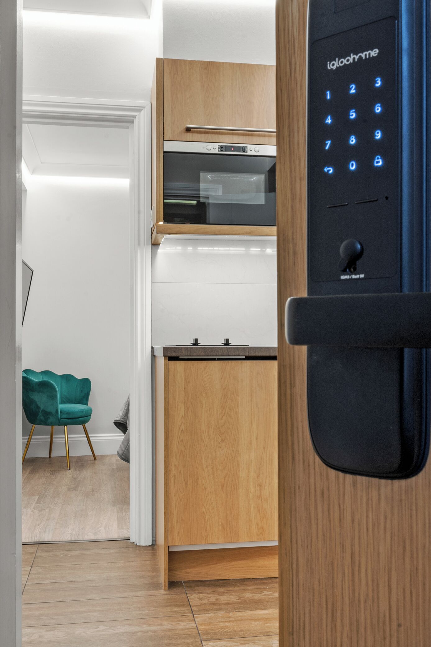 A modern kitchen with a built-in oven and a digital keypad lock.