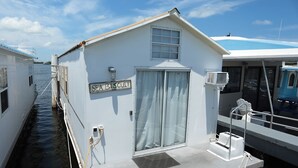 Un petit bâtiment blanc avec une enseigne sur laquelle on peut lire « SEA BISCUIT », situé sur un quai.