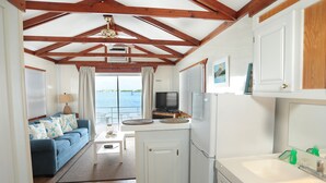 Une cuisine compacte avec un coin repas, un canapé et une vue sur la mer.