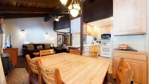 Un accogliente soggiorno con un tavolo da pranzo in legno e sedie, un divano e una ventola a soffitto.
