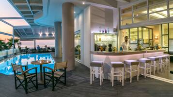A poolside bar area with a bar counter, seating, and a view of the pool.