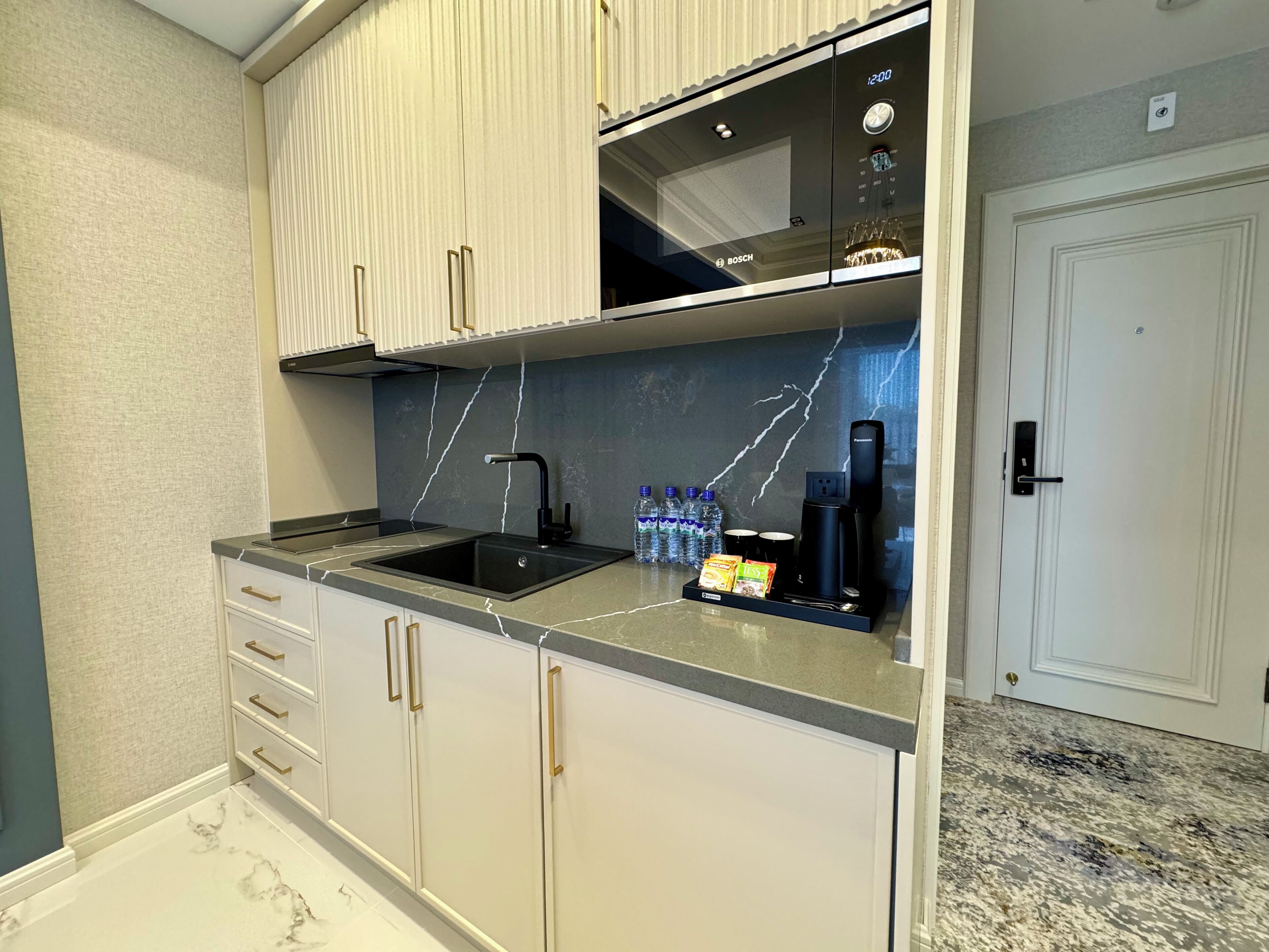 A modern kitchen with a Bosch microwave, a sink, and a coffee maker.