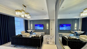 A modern hotel room with a large bed, a seating area with a sofa and armchairs, a TV, and a large mirror. - Sultan (Qarshi)