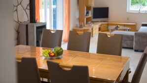 A dining area with a wooden table, chairs, and a fruit bowl. - Modern 4* villa with high-quality furnishings and private pool (Milohnići)
