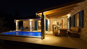 A stone building with a swimming pool, outdoor seating, and a covered patio area. - Modern 4* villa with high-quality furnishings and private pool (Milohnići)