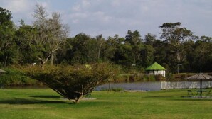 A park with a pond, a gazebo, and a small building with a green roof. - Bantu Mountain Lodge (Naro Moru)