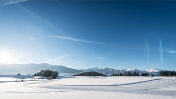 A snowy landscape with mountains in the background and a clear sky.