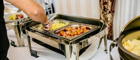 Montaje de bufé con recipientes etiquetados para diferentes alimentos.