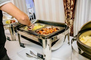 Noutopöytä, jossa on eri ruokalajeja varten merkityt astiat.