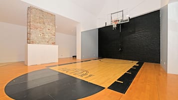 Una cancha de baloncesto con piso de madera y diseño en colores negro y amarillo.