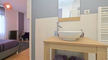 Une salle de bain moderne avec un meuble-lavabo en bois, un grand miroir et un lavabo blanc.