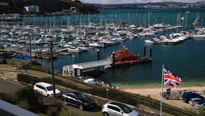 A marina with numerous boats docked, a bridge, and a flagpole with a flag. - Devoncoast Seaview Apartments (Brixham)