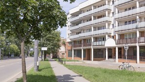 A multi-story residential building with balconies, a paved sidewalk, and a bicycle parked outside. - Apartament Praga Tower (Warsaw)