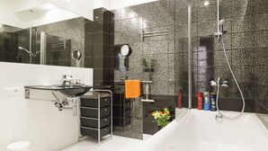 A modern bathroom with a glass sink, a bathtub, and a shower. - Apartament Praga Tower (Warsaw)