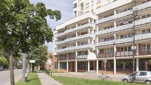 A multi-story residential building with balconies, a covered entrance, and a sidewalk with a bicycle. - Apartament Praga Tower (Warsaw)