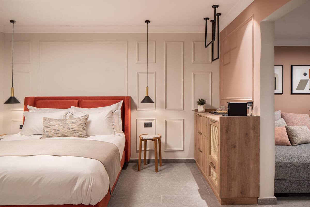 A modern bedroom with a large bed, a wooden nightstand, and a desk.