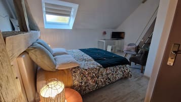 Ein Schlafzimmer mit Bett, Schreibtisch, Fernseher und Fenster.