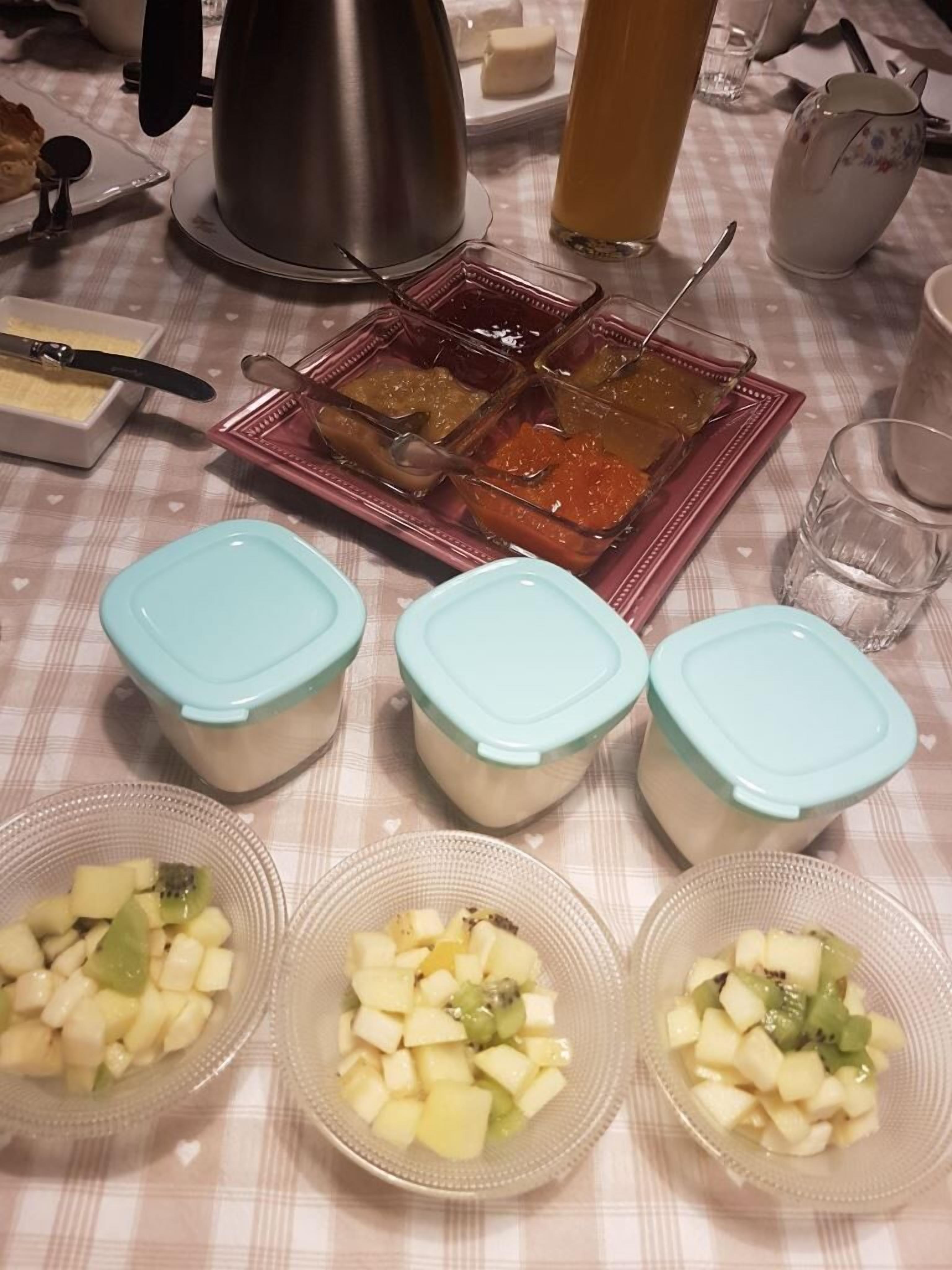 A table with food items, including fruit and condiments, on a checkered tablecloth.