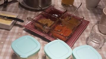 A table with food items, including fruit and condiments, on a checkered tablecloth.