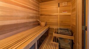 A sauna with wooden benches, a wooden bench with a basket, and a sauna heater. - Unobstructed Lake View 10 min to Snowbasin, Sleeps 12 (Huntsville)