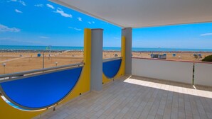 Un balcon avec vue sur une plage et la mer.