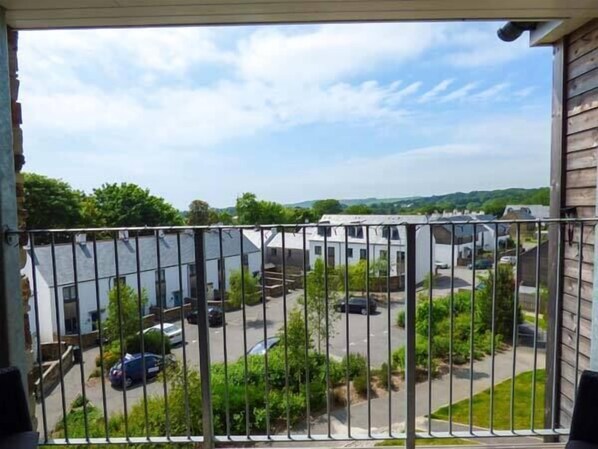 Enjoy the serene view of the surrounding greenery from this balcony.