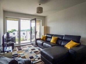 Relax in this stylish living room with a comfortable sofa, large sliding door to an outdoor area, and a cozy rug.
