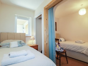 Cozy retreat with a large bed, bedside table, and comfortable chair.