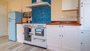 Eine Küche mit einem weißen Herd, einem Backofen und einem blauen Kühlschrank.