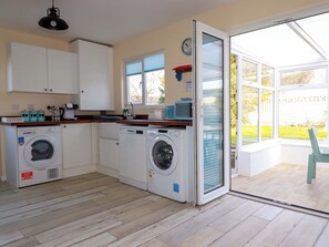 A kitchen with built-in appliances, a window, and a door leading to a patio.