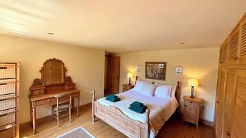 Quarto com cama de madeira, mesas de cabeceira, escrivaninha, cadeira e guarda-roupa.