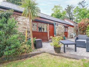 Relax in a charming cottage with a well-maintained garden and cozy patio area.