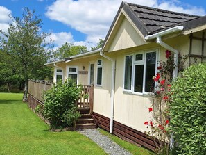 Een gelijkvloers huis met een veranda, een kleine tuin en een bordje met de tekst 'Willow'.